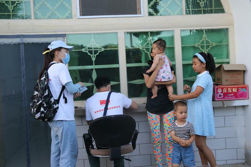 07+团队成员帮抱着孩子的妈妈在明信片上写下对孩子不同年龄段的人生规划+浙江大学陈昊炜提供