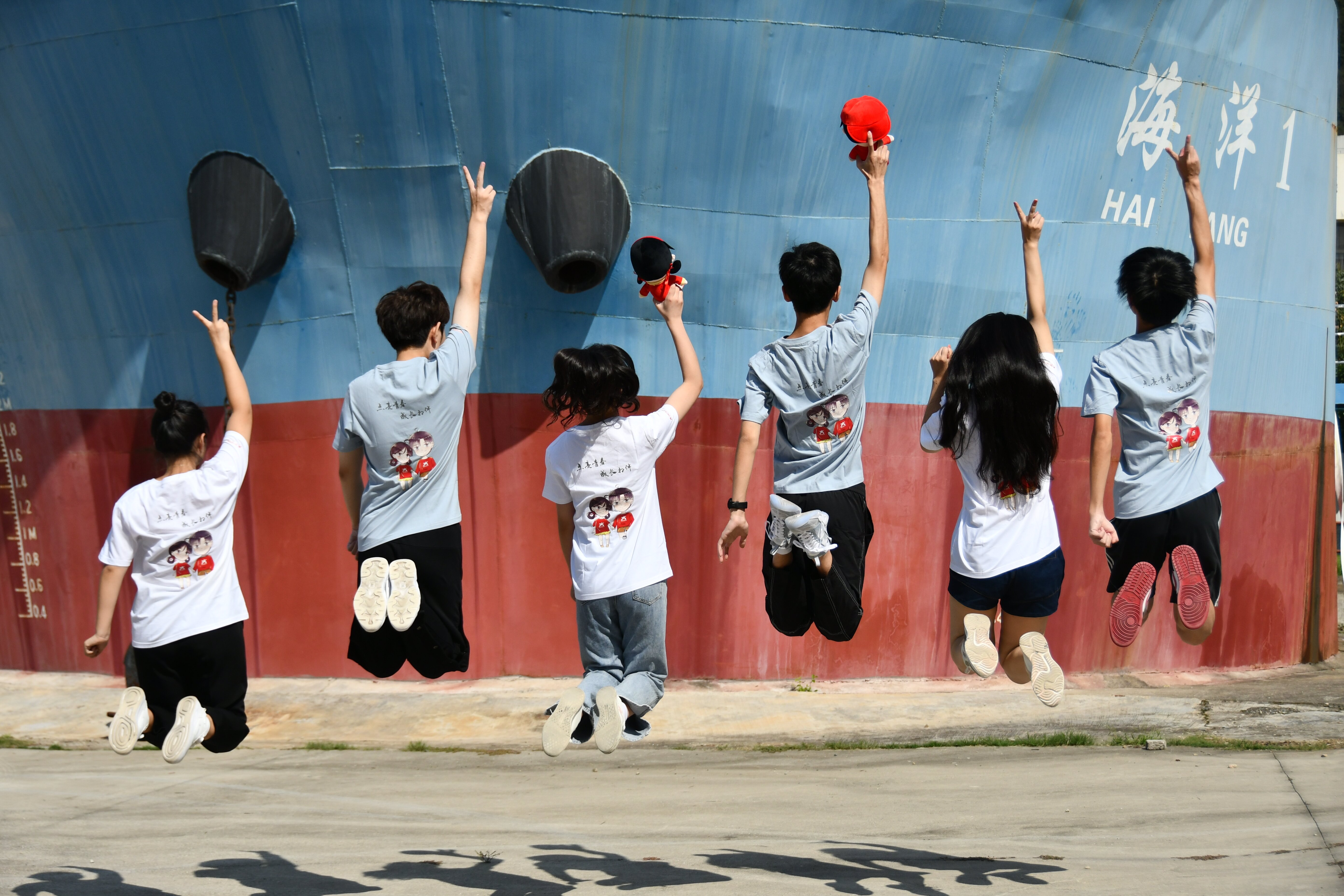 校园网络通讯站的同学们身着印有小中兄妹图案的文化衫在学院船模前默契齐跳，跃动青春风采