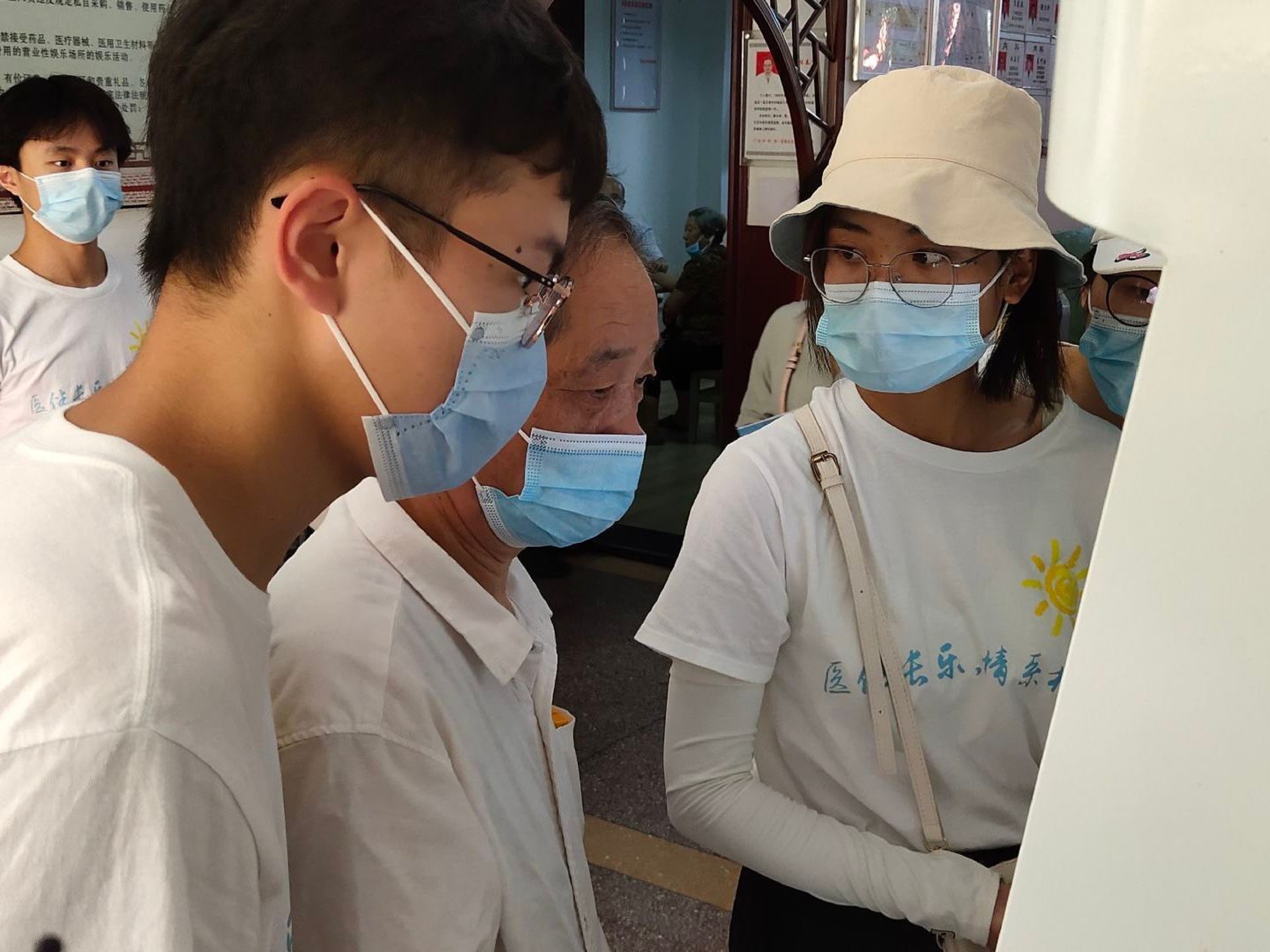 实践队队员帮助患者打印体检报告单 翁嘉豪摄.jpg 实践队队员帮助患者打印体检报告单 翁嘉豪摄.jpg
