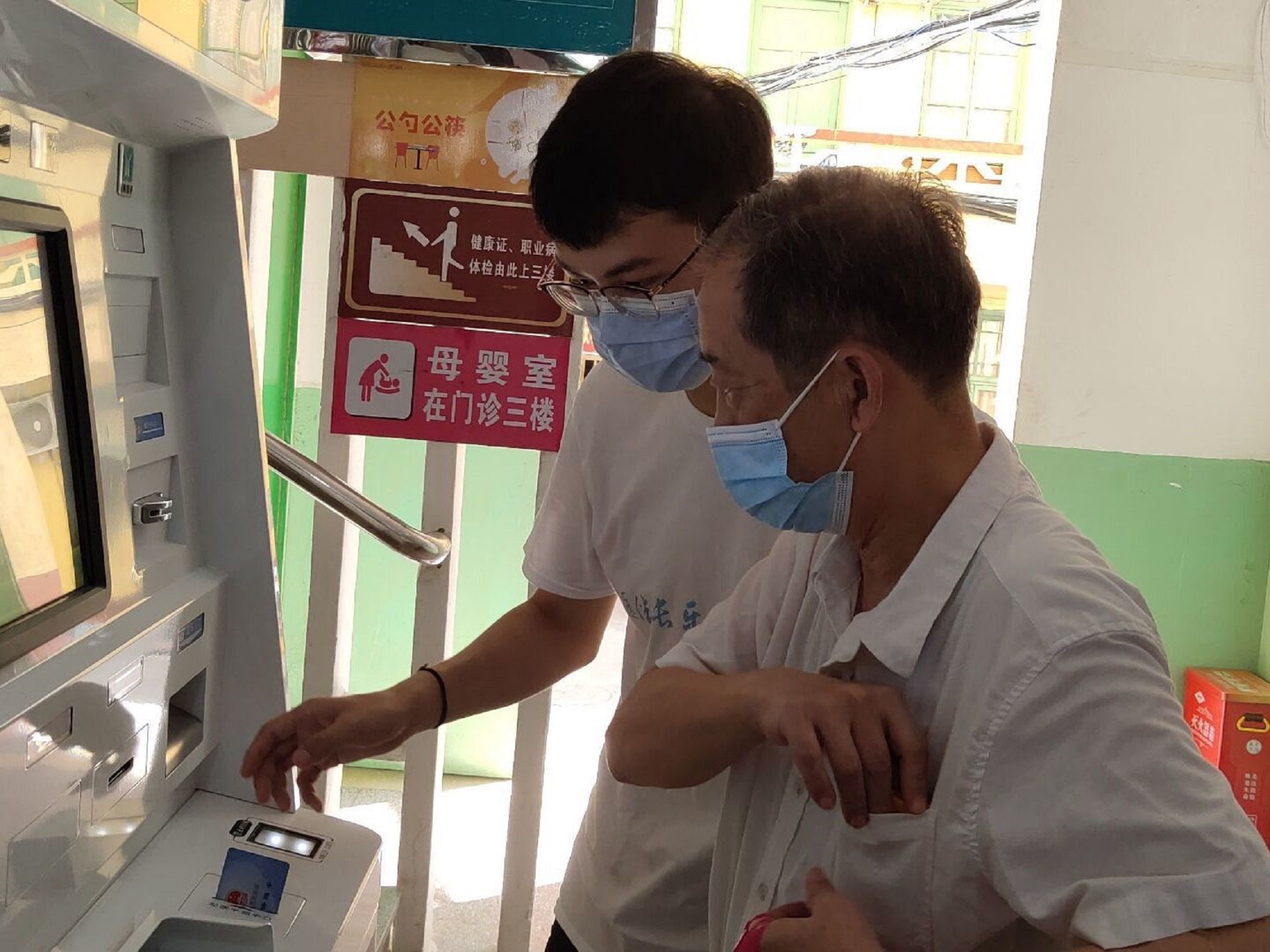 队员林震宇帮助患者进行机器缴费 翁嘉豪摄.jpg 队员林震宇帮助患者进行机器缴费 翁嘉豪摄.jpg